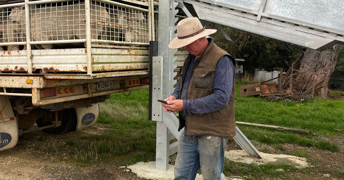 Scott Young next to truck with phone in hand